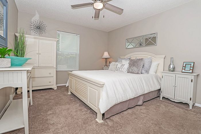 Inviting bedroom with elegant decor, plush carpet, and stylish furniture, perfect for relaxation and comfort.