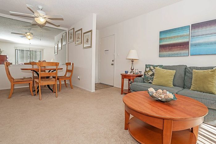 Cozy living and dining area with stylish wooden furniture, contemporary artwork, and elegant lighting, perfect for relaxation and entertaining.