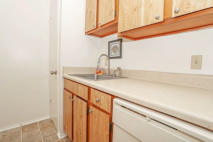 Bright and welcoming kitchen area with elegant wooden cabinets and spacious countertops, perfect for culinary creativity.