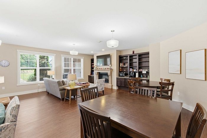 Bright and inviting open-concept living area with elegant hardwood floors, ample natural light, and cozy fireplace.