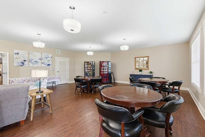 Inviting communal space featuring elegant round tables, plush seating, and bright lighting for a welcoming atmosphere.