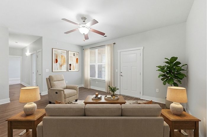Inviting living room with elegant furniture, soothing color palette, and natural light streaming through large windows, perfect for relaxation.