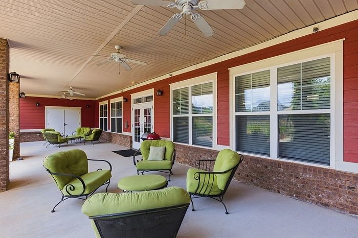 Charming apartment veranda with cozy seating and vibrant green cushions, perfect for relaxation and outdoor enjoyment.