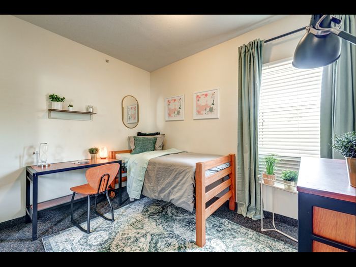 Bedroom with desk and large window  in apartment at University Gate | Erie, PA Apartments.