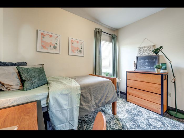 Furnished bedroom with natural lighting in apartment at University Gate | Erie, PA Apartments.