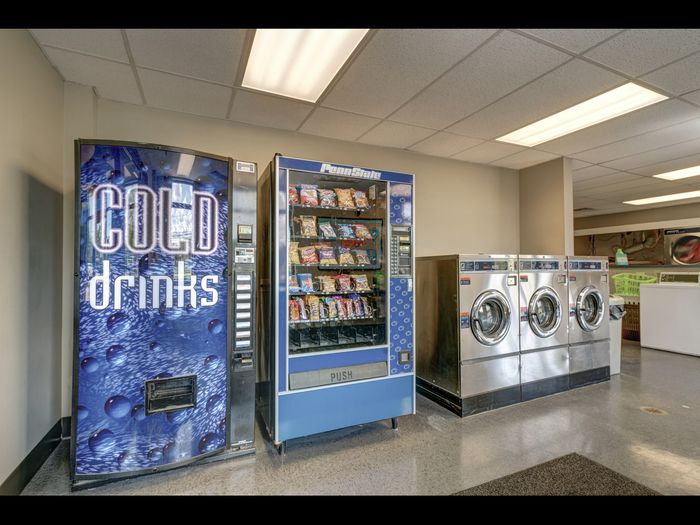 Vending machines in laundry room with extra large washing machines at University Gate | Erie, PA Apartments.