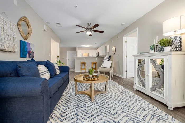 Furnished living room leading into kitchen and breakfast bar