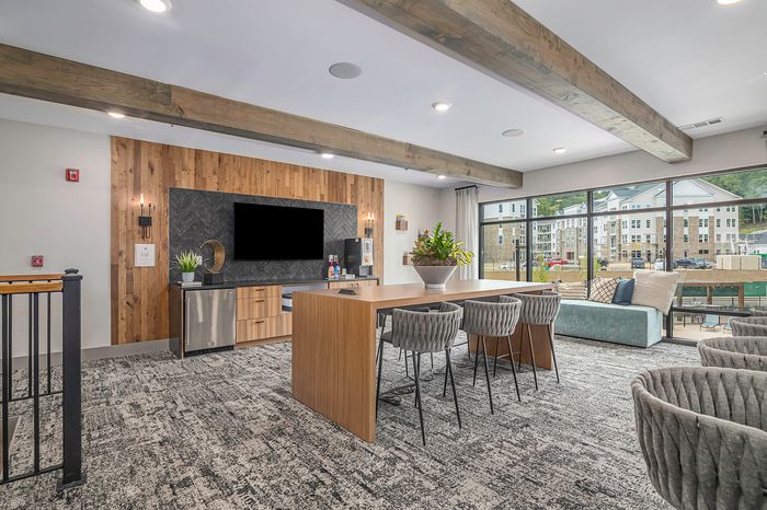 furnished clubroom area with television, table and seating