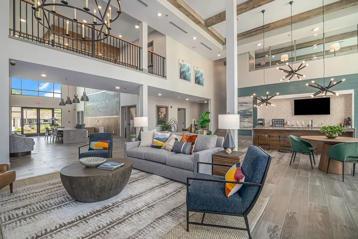furnsihed clubroom with seatings, tables, and high ceilings and windows