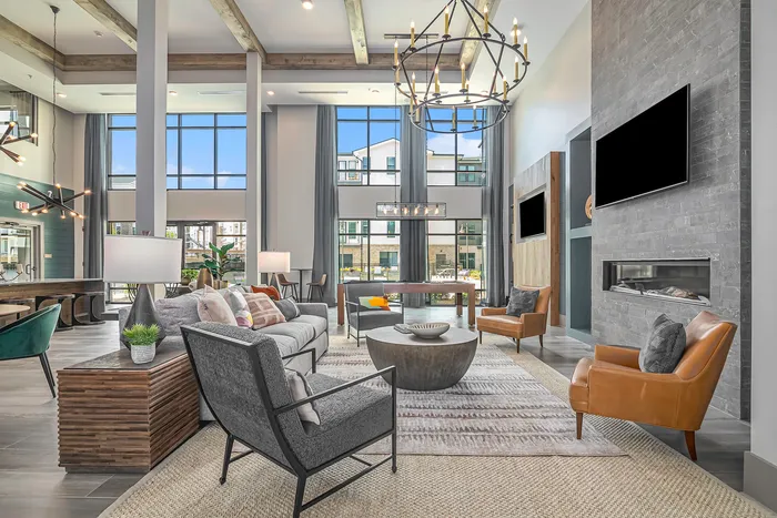 furnished clubroom with seating, high ceilings and television
