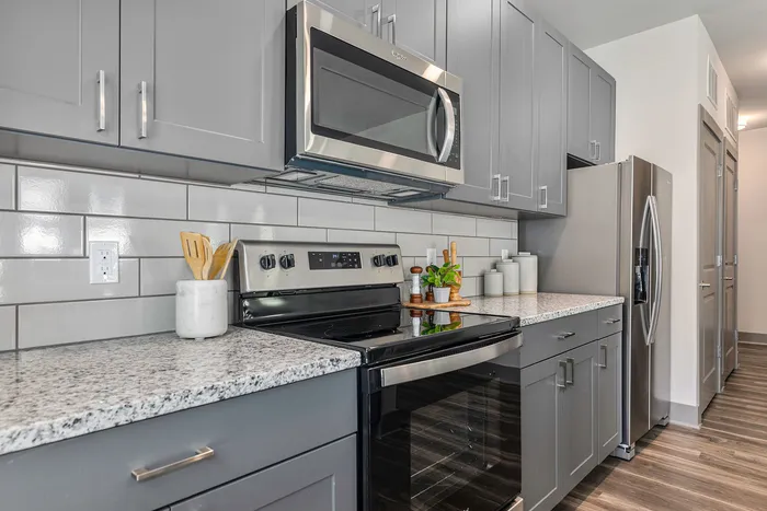 furnished kitchen with microwave and stove in apartment home