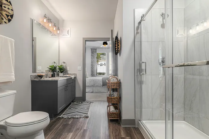 Birmingham Luxury Apartments - Tributary Rise - Bathroom With Large Vanity Mirror, Designer Lighting, And Walk-In Glass-Encased Shower.
