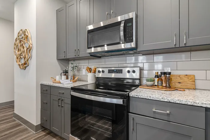 furnished kitchen with stove, oven and microwave in apartment home