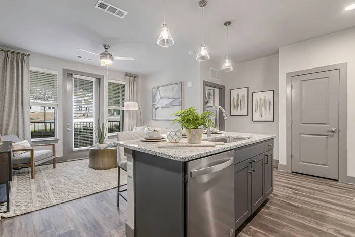 furnished kitchen with island and living area in apartment home