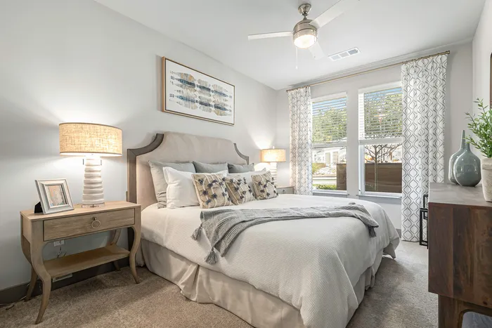 Pet-Friendly Apartments In Birmingham - Tributary Rise - Spacious Bedroom With Plush Carpeting, Ceiling Fan, And Windows With Blinds.