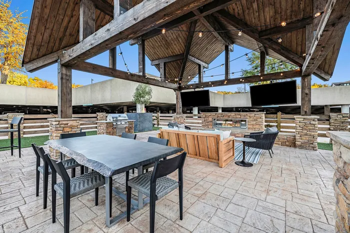 Outdoor dining area with firepit and TVs