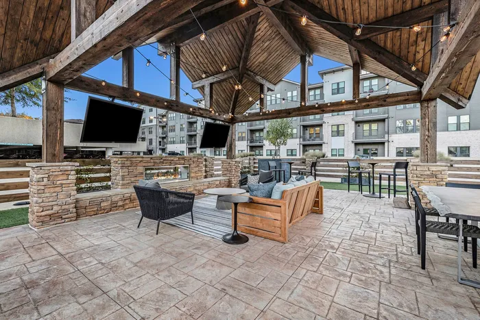 Outdoor dining area with firepit and TVs