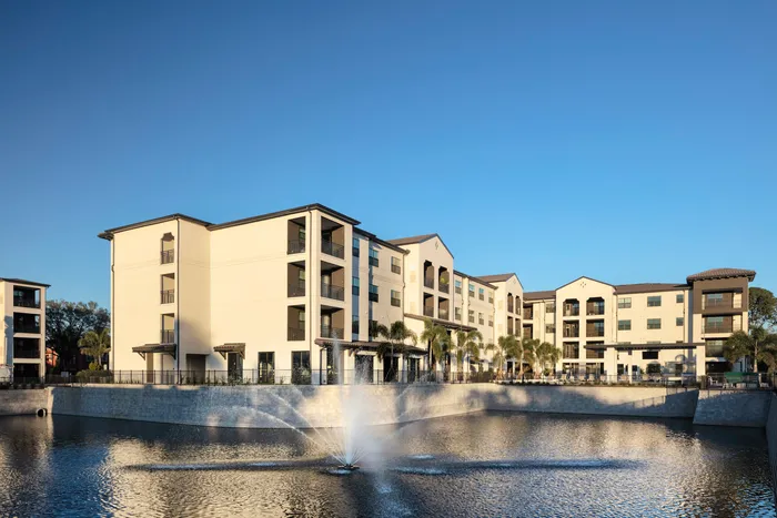 exterior apartment building with lake and fountain on sunny day