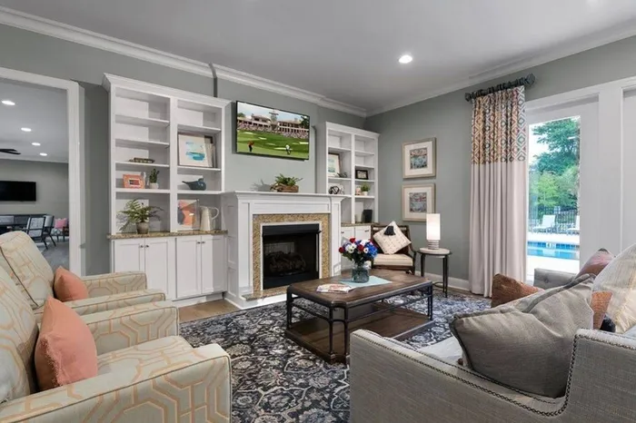 Lounge area with fire place, flatscreen tv, and book case