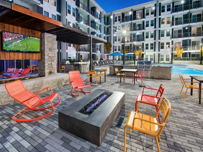 One-BR Apartments In Atlanta, GA - Spectrum on Spring - Outdoor Kitchen Near The Pool With State-of-the-Art Grilling Stations, TV, Firepit, Tables, Chairs, And Lounge Area