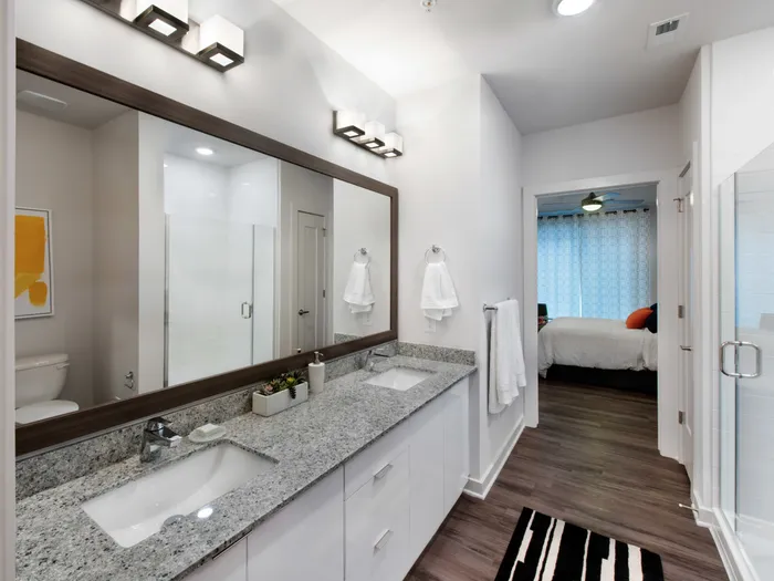 furnished bathroom with doubl doorse sinks and glass shower