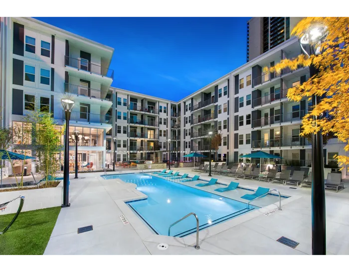 Two-BR Apartments In Atlanta, GA - Spectrum on Spring - Resort-Style Pool With Umbrellas, Lounge Chairs, And Outdoor Light Poles