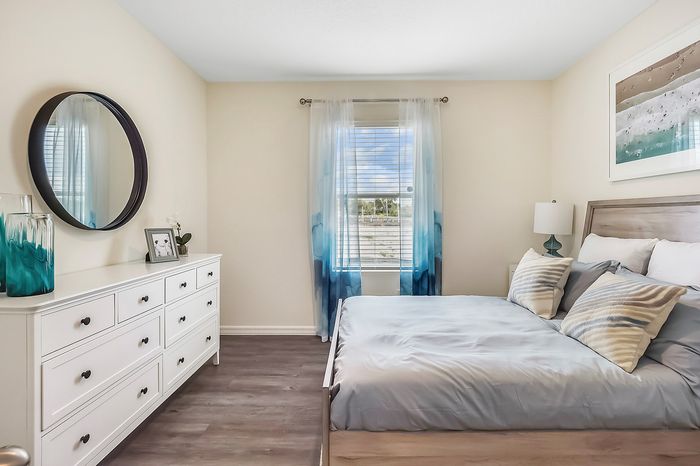furnished bedroom with bed and dresser in home