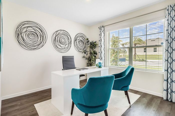 furnished study with desk and chairs in home