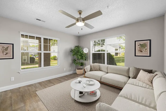 Furnished living room with windows and lighted ceiling fan