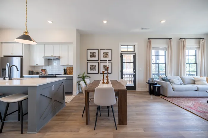 Furnished dining room with table and chairs between furnished kitchen and living room
