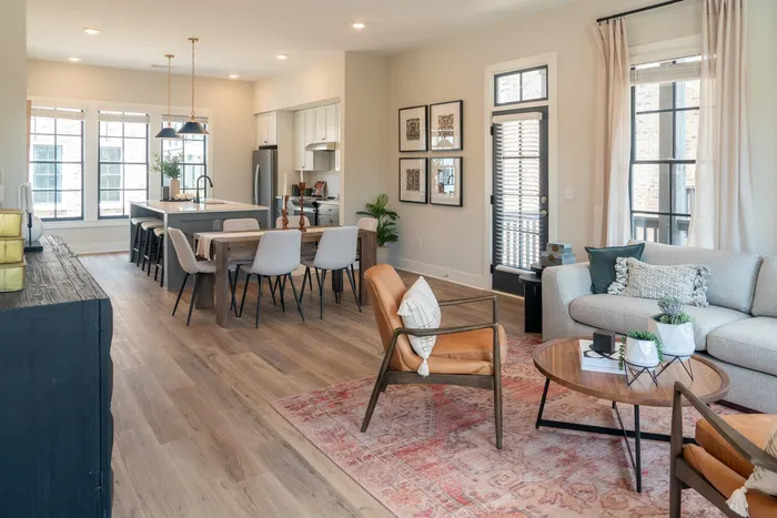 Furnished living room with couch and chairs with furnished dining room and kitchen