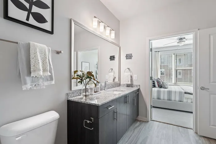 furnished bathroom with sink and bedroom in background in apartment home