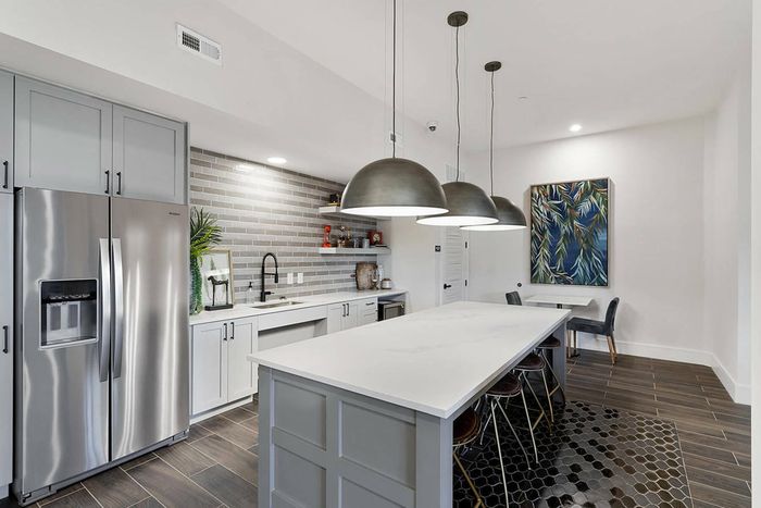 furnished kitchen area with island and refrigerator in clubhouse