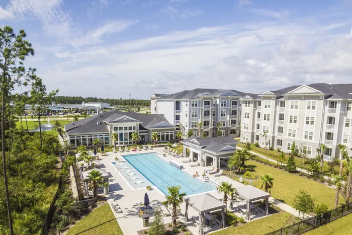 aerial view of apartment buildings and pool area on sunny day