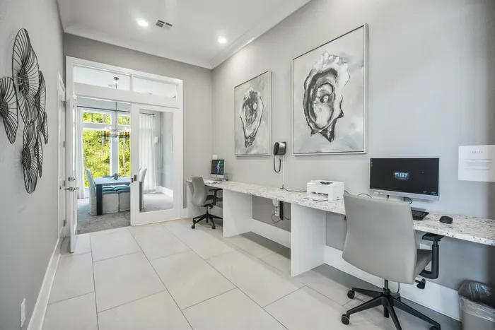 furnished computer room with desktop monitors, desk and chairs