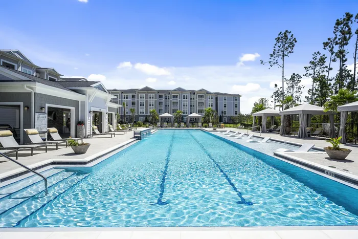 outdoor pool next to clubroom and apartment building in daytime