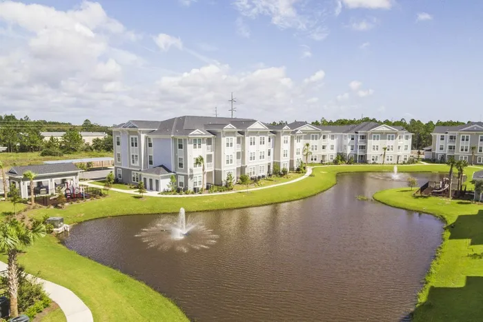 exterior apartment building with lake and water fountain in daytime