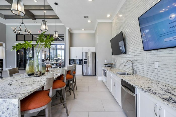 furnished clubroom with kitchen area, island and seating