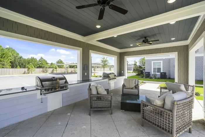 outdoor grilling area with table and chairs in daytime