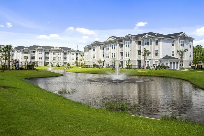 exterior apartment building with lake and water fountain in daytime