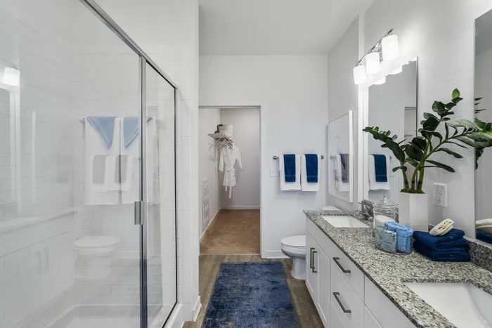furnished bathroom with shower, sink and toilet in apartment home