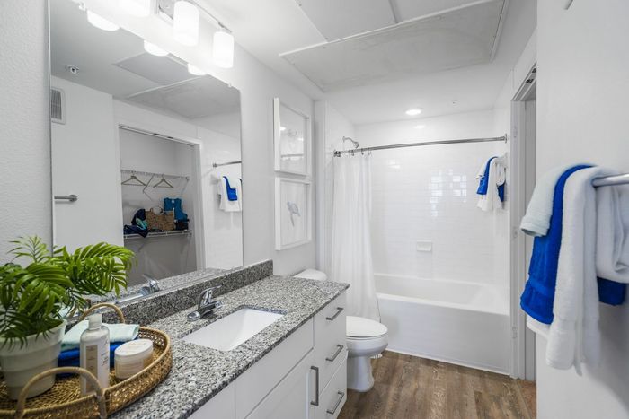 furnished bathroom with sink, toilet and shower tub in apartment home