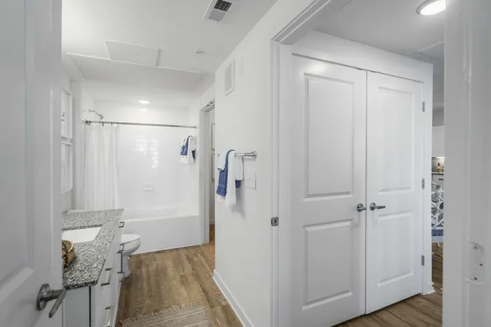 furnished bathroom with sink, toilet and shower tub in apartment home