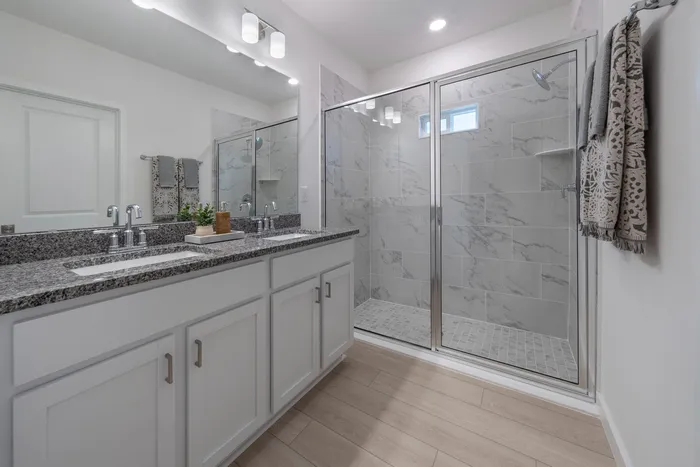 Bathroom with two sinks and standing glass shower