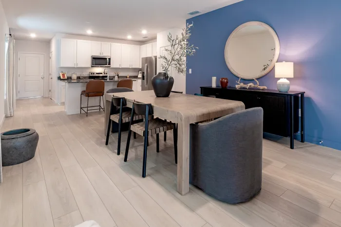 Furnished dining room with dining tabe and chairs and blue accent wall