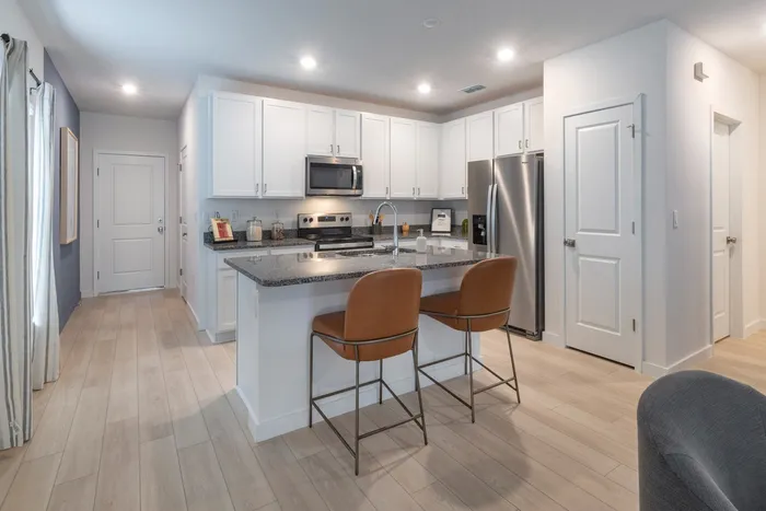 Kitchen with stainless steel appliances and litchen island with barstools