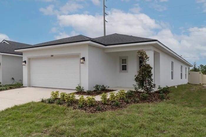 Exterior of front of home with garage and green lawn