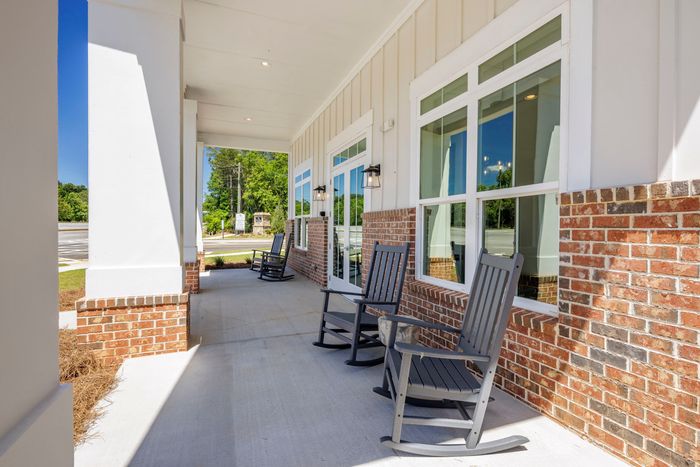 furnished patio area with rocking chairs on sunny day