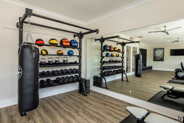 furnished fitness center with equipment and wall mirror