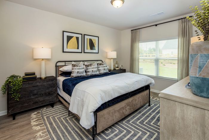 Three-Bedroom Homes in Loganville, GA - Cottages at Loganville - Bedroom with Spacious Window, Double Nightstands, and Large Bed